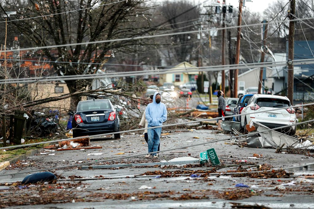 Bowling Green, Kentucky, residents look at  the damage following a tornado that struck the area on December 11, 2021. - Tornadoes ripped through five US states overnight, leaving more than 70 people dead Saturday in Kentucky and causing multiple fatalities at an Amazon warehouse in Illinois that suffered "catastrophic damage" with around 100 people trapped inside. The western Kentucky town of Mayfield was "ground zero" of the storm -- a scene of "massive devastation," one official said. (Photo by Gunnar Word / AFP) (Photo by GUNNAR WORD/AFP via Getty Images)